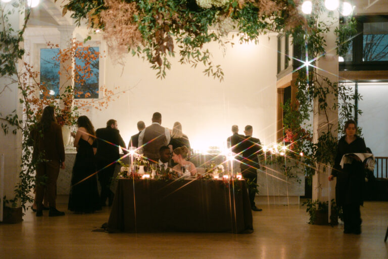 Newlyweds seated at a candlelit sweetheart table at Gordon Green