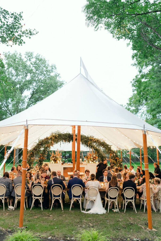 Guests dining beneath a sailcloth tent at a luxury Cleveland wedding