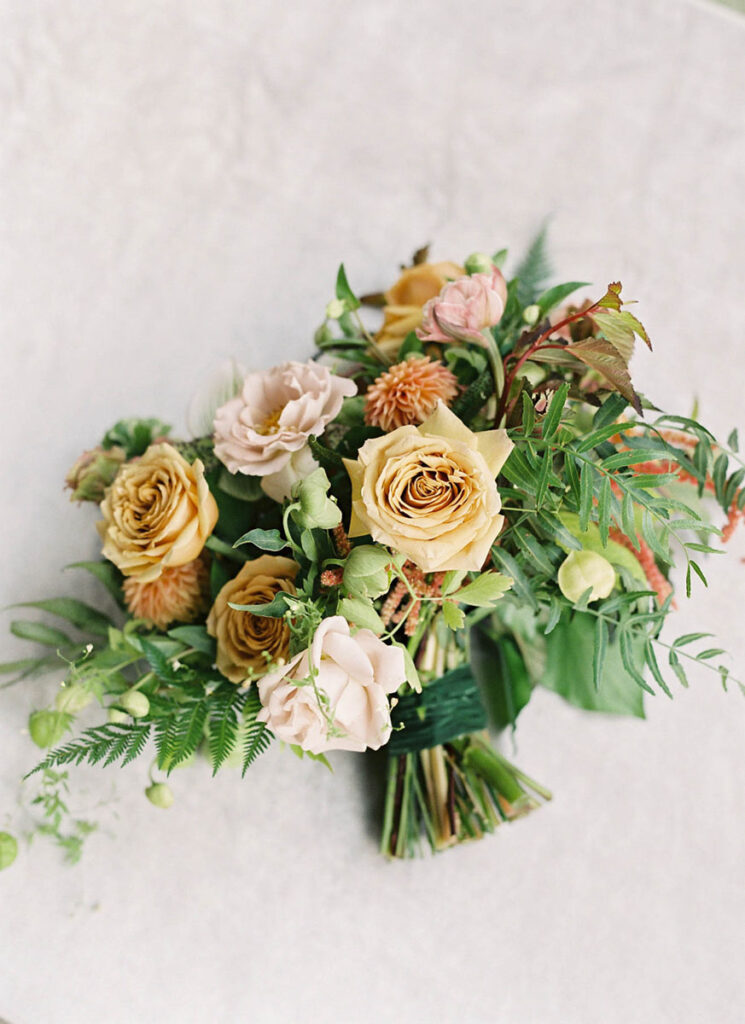 Neutral bridal bouquet with champagne roses, blush flowers, and greenery