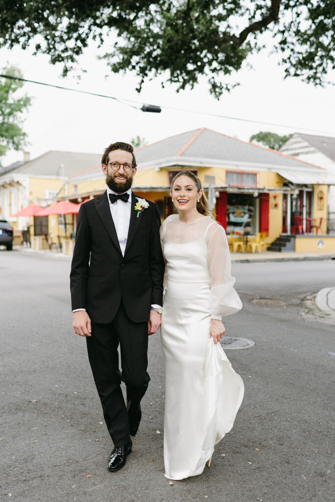 Bride and groom walking through a colorful New Orleans neighborhood