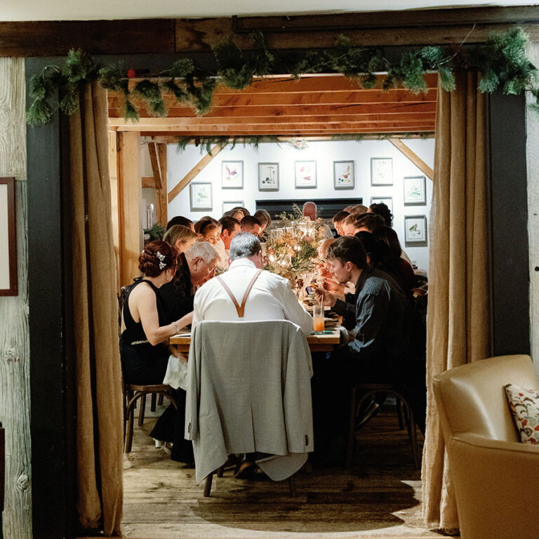 Wedding guests gathered around a long table for an intimate Vermont dinner