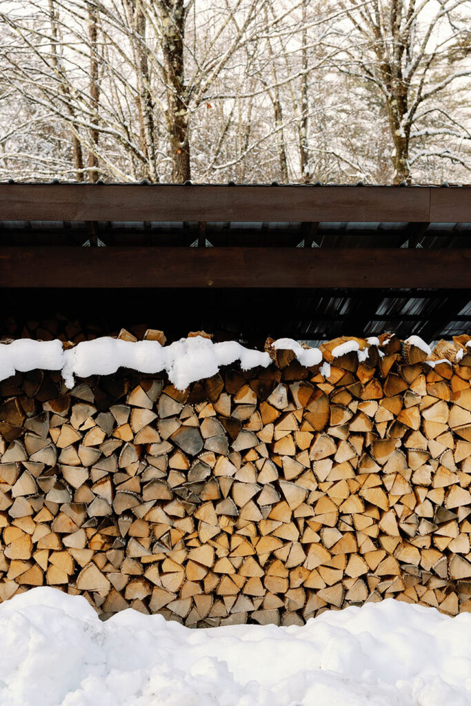 Stacked firewood covered in snow at a Vermont winter wedding venue
