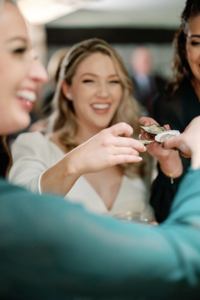 Bride sharing oysters with friends during an intimate Vermont wedding
