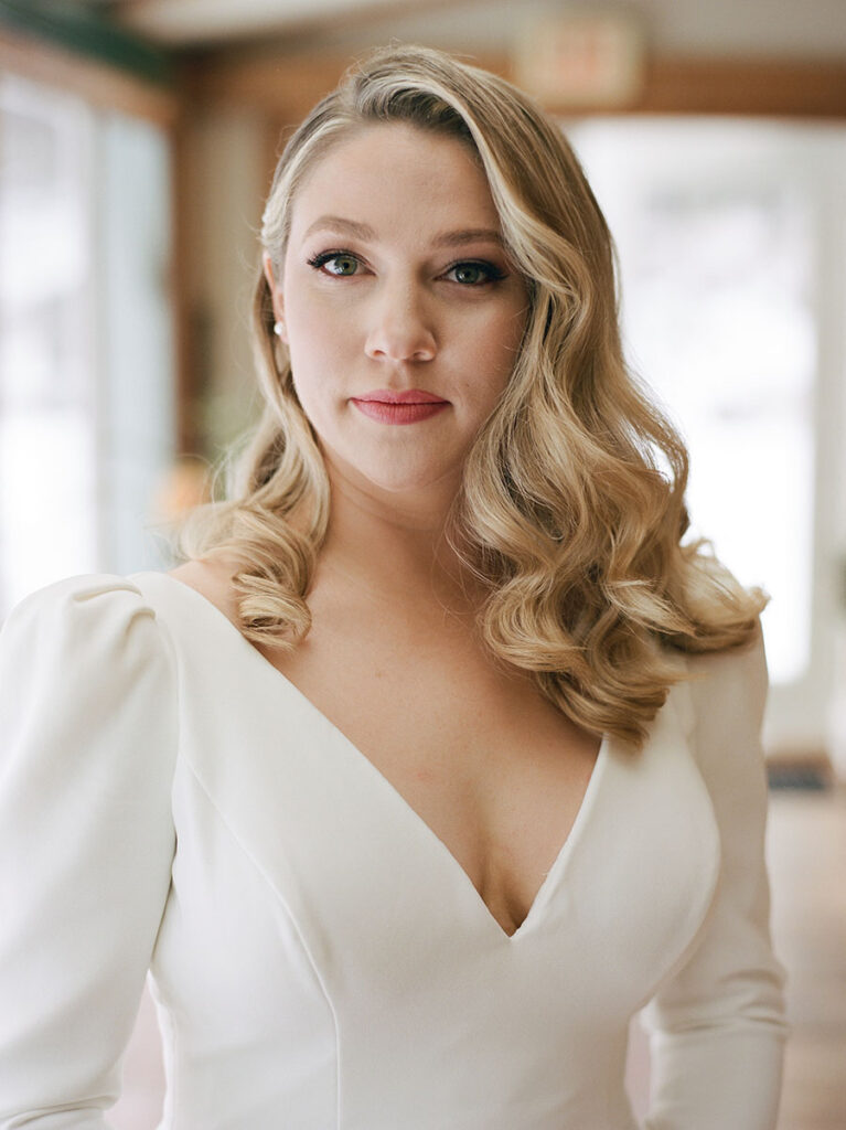 Bride in a modern long-sleeved wedding gown at a Vermont winter wedding