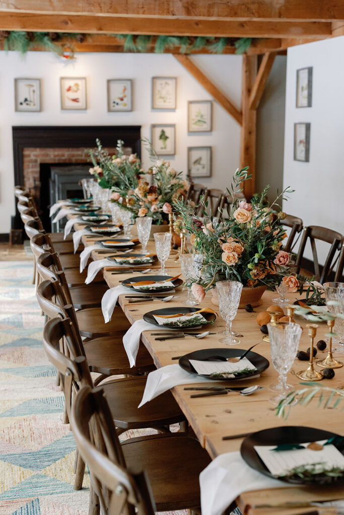 Long Vermont wedding reception table with romantic florals and rustic wood details