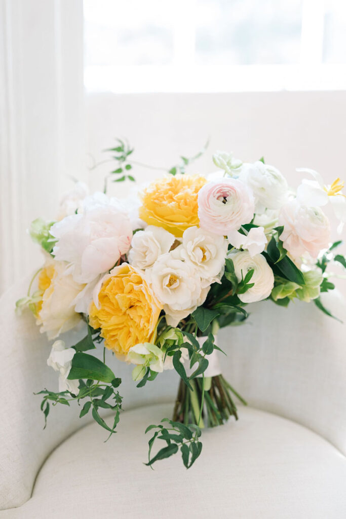 Yellow, blush, and white bridal bouquet with trailing greenery